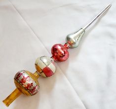 an assortment of colorful glass ornaments on a white tablecloth with a pair of tongs