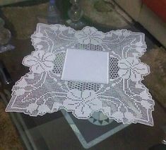 a white doily sitting on top of a glass table