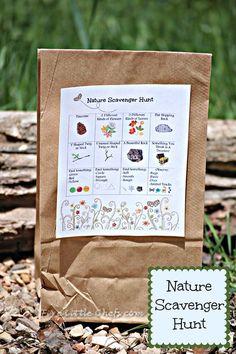 a brown paper bag sitting on the ground next to some grass and rocks, with a sticker that says nature scavenger hunt