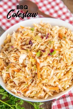 a white bowl filled with coleslaw on top of a red and white checkered table cloth