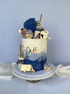 a blue and white cake with gold decorations on it's top that says, dad