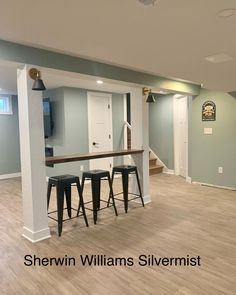 an empty living room with bar stools in it