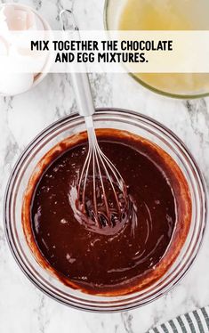 the chocolate mixture is being mixed together in a glass bowl with a whisk