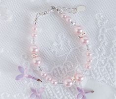 Gorgeous bracelet with beautiful pink pearls and High-end crystals accented with sparkling silver rhondelles.  This is a timeless keepsake gift perfect for newborn infant baby girl.  Also makes a sweet bracelet for toddlers, kids and girls who love pink things that sparkle! Bracelet comes in a beautiful gift box with care instructions ready for gifting.   FREE SHIPPING ON STANDARD ORDERS - Ships within 1 business day! Each bracelet has a grow-with-me extension chain for a perfect fit.  Please see sizing chart below: SM (0-12 months) 4 - 4.5 inches MED (1-5 years) 5 - 5.5 inches LG (6-12 years) 6 - 6.5 inches Want to add additional charms?  https://etsy.me/2U56Hks Pink Pearl Beaded Bracelet For Birthday, Elegant Pink Pearl Bracelet For Birthday, Pink Pearl Bracelet For Party, Pink Pearl Bracelet For Birthday, Pink Beaded Pearl Bracelet For Wedding, Pink Hypoallergenic Bracelets For Wedding, Pink Pearl Bracelets For Mother's Day, Pink Pearl Party Bracelet, Adjustable Pink Pearl Bracelet For Mother's Day