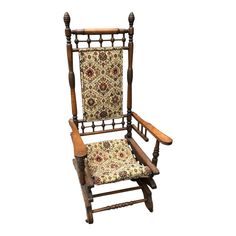 an old wooden rocking chair with floral upholstered seat and foot rest, on a white background