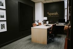 an office with black walls and wooden desks