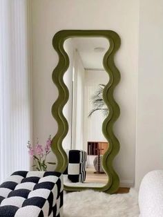 a mirror that is sitting on top of a rug in front of a chair and ottoman