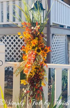 an arrangement of flowers on a white fence