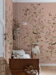 a bedroom with floral wallpaper and a bed in the foreground, next to a wicker basket