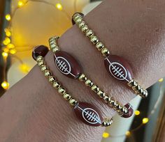 two bracelets with football charms on them