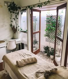 a bedroom with an open door leading to another room that has plants growing on the walls