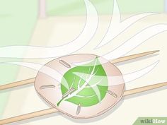 a green leaf on top of two chopsticks