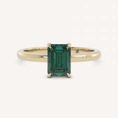 an emerald colored ring with gold band