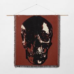 a red wall hanging with a black and white skull on it's front side