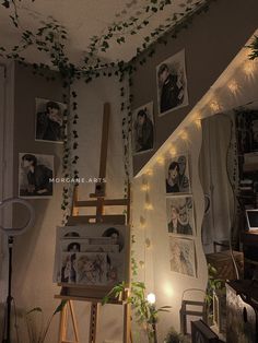 a room with pictures on the wall and lights hanging from the ceiling, plants growing up to the ceiling