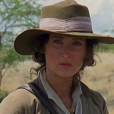 a woman wearing a hat in the middle of a field