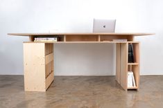 a wooden desk with a laptop on top of it and bookshelves below the desk