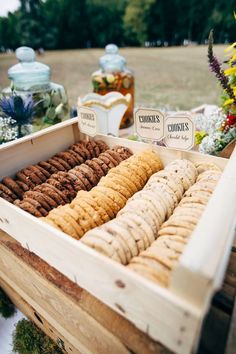 a wooden box filled with crackers next to flowers and other items on a table