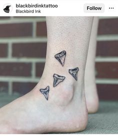 three small tattoos on the foot of a woman's feet, with black ink