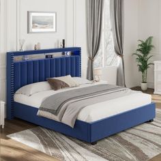 a bed with blue headboard and foot board in a white walled room, next to a window