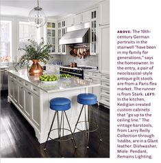 a kitchen with white cabinets and blue stools next to an island in the middle