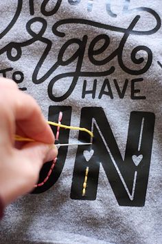 someone is knitting on the back of a t - shirt that says we get to have fun