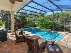 a backyard with a swimming pool and patio furniture