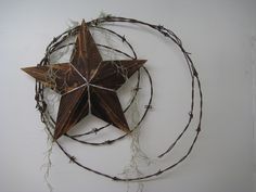 a star with barbed wire around it on a white wall next to a circular object