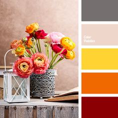 a vase with flowers in it sitting on a table next to an open book and color swatches