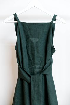 a green dress hanging on a white hanger