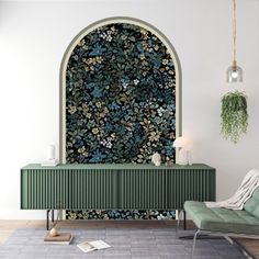 a living room with a green couch and wallpaper