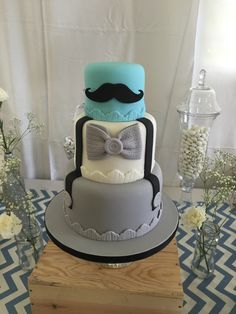 a three tiered cake with a mustache and bow tie on top