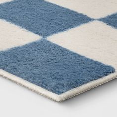 a blue and white rug with squares on the bottom is shown in close up view