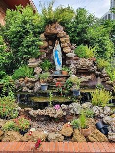 the statue is surrounded by plants and rocks