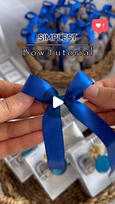 two hands holding a blue bow with the words, simplest bow tutorial