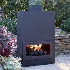 an outdoor fireplace in the middle of a garden