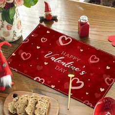 a valentine's day table setting with bread, wine glasses and other holiday decorations