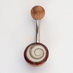 a wooden spoon with a white and brown swirl on it's side is hanging from a metal hook