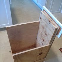 a wooden box sitting on top of a kitchen floor