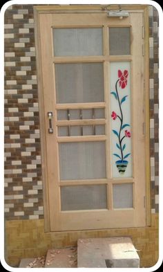 a wooden door with flowers painted on the glass and wood frame, in front of a mosaic tile wall