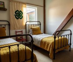 two twin beds in a small room with yellow bedding