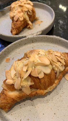 two plates with pastries on them sitting on a counter top next to each other