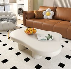 a white coffee table sitting on top of a black and white floor next to a couch