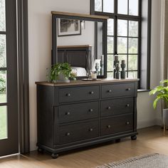 a bedroom with a dresser, mirror and potted plant