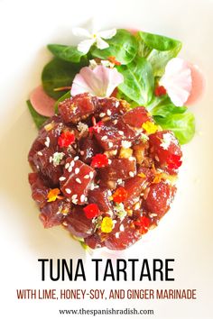 a white plate topped with meat and veggies on top of green leafy leaves