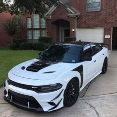 a white sports car parked in front of a house