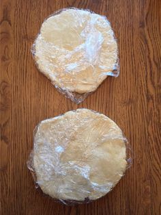 two uncooked pies sitting on top of a wooden table