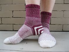 the legs of a person wearing socks with white and red designs