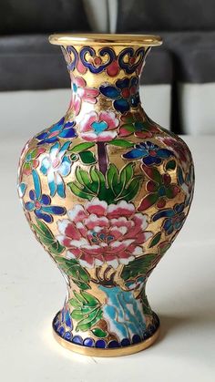 a colorful vase sitting on top of a white table