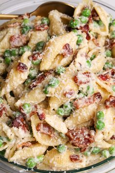 a pasta dish with peas, bacon and cheese in a glass bowl on a table